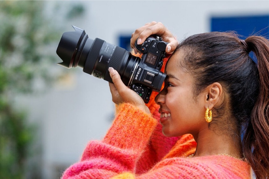 Žena fotografujúca pomocou objektívu Tamron 35–100 mm f/2.8 Di III VXD