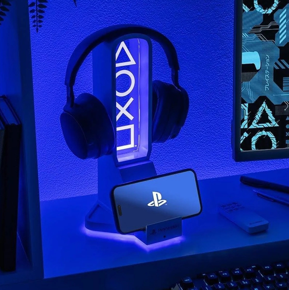 Efektne zeleno nasvietený stojan so slúchadlami a mobilným telefónom.