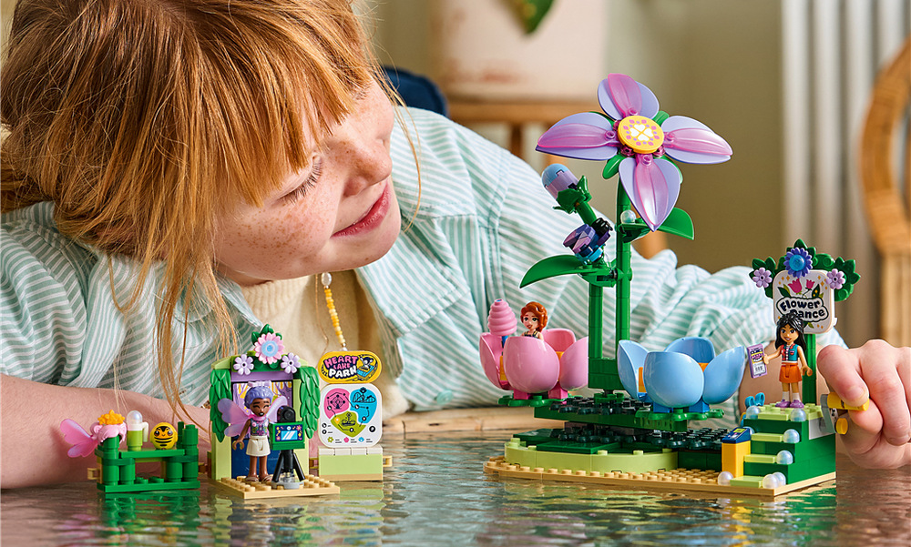 Stavebnica LEGO® Friends 42702 Kvietkový kolotoč s vílami Aliya, Liann a Autumn nasadzujú vílie doplnky a vymýšľajú rozprávkové dobrodružstvá v lunaparku.