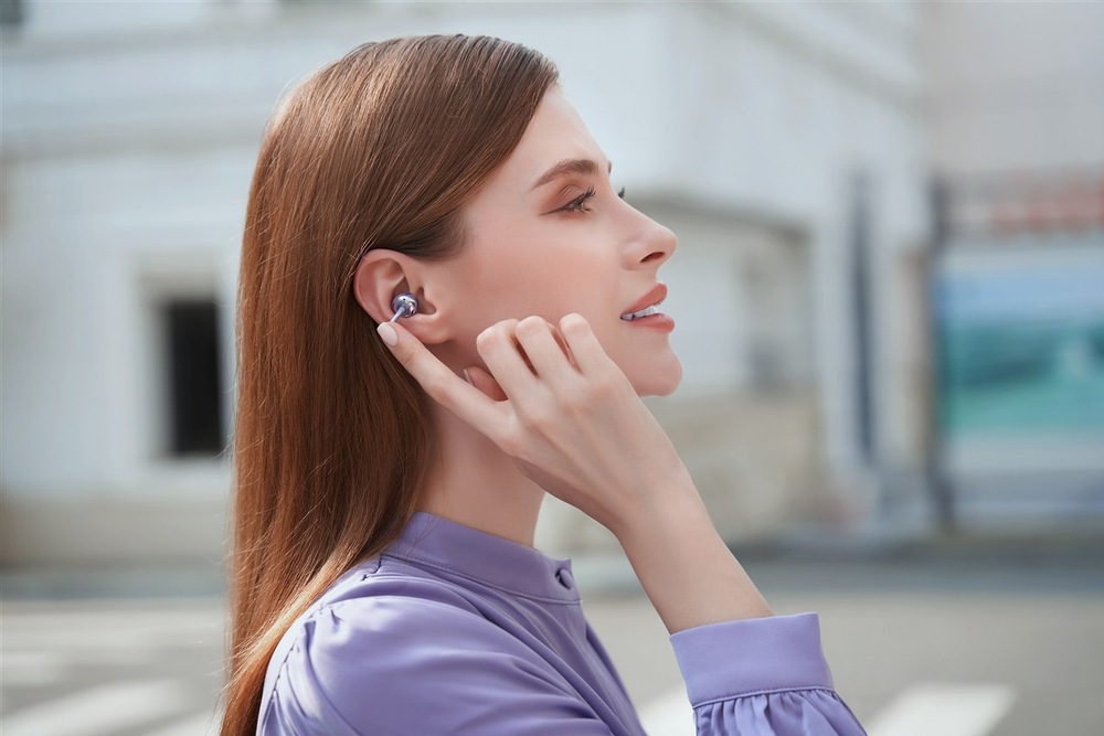 Slúchadlá HONOR CHOICE Earbuds Clip čierna Žena na ulici sa dotýka slúchadla HONOR CHOICE Earbuds Clip
