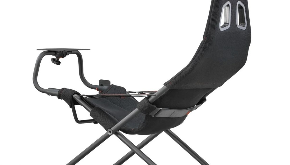 Inovatívna čierna herná stolička s ergonomickým dizajnom, opierkou hlavy, robustným kovovým rámom a nastaviteľným područím s malou plošinou.