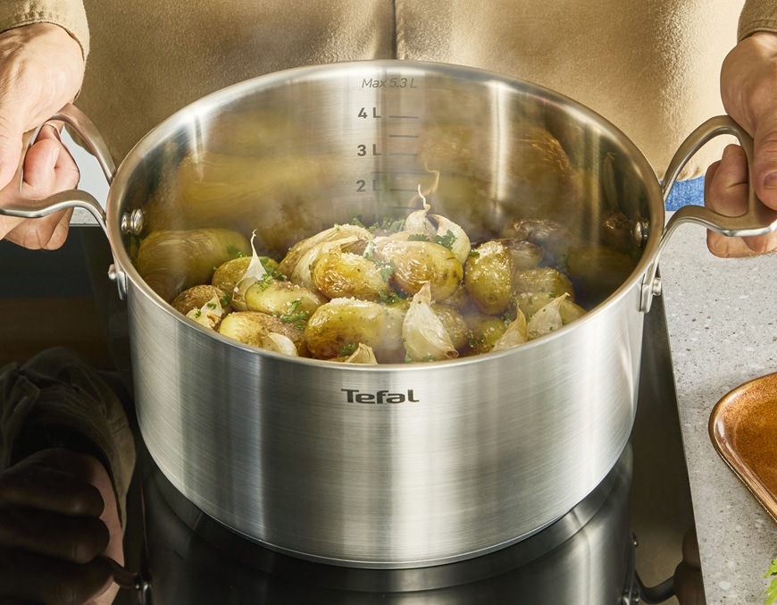 Hrniec s pokrievkou Tefal Extreme E5296104, 22 cm nerez Muž pripravuje prílohu k hlavnému chodu v hrnci Tefal.