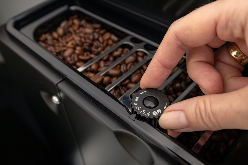Espresso Gorenje G800 CM4G8BG čierna Na obrázku je ruka nastavujúca stupeň intenzity kávy.