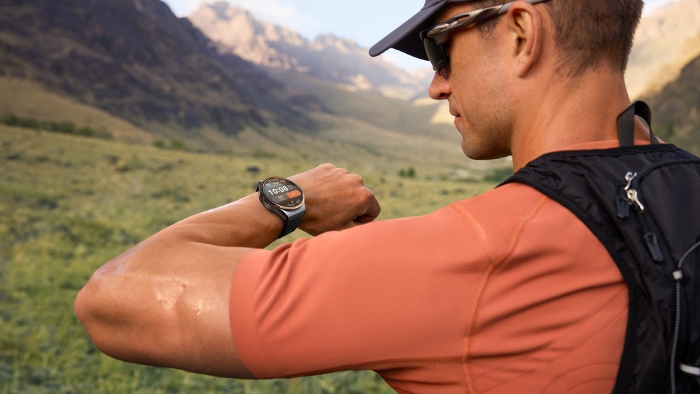 Inteligentné hodinky Huawei Watch 6 Pro 46 mm čierne/titánová farba Turista s batohom v horskej krajine kontroluje inteligentné hodinky na zápästí