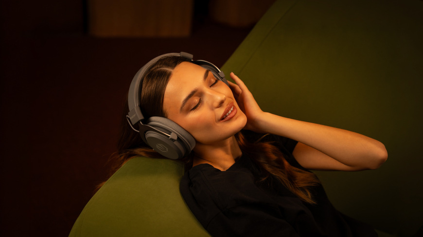 Headset ENDORFY VIRO Infra Wireless Alt Grey sivý Užívateľka odpočívajúca s nasadeným headsetom ENDORFY VIRO Infra Wireless Alt Grey v teplom ambientnom osvetlení
