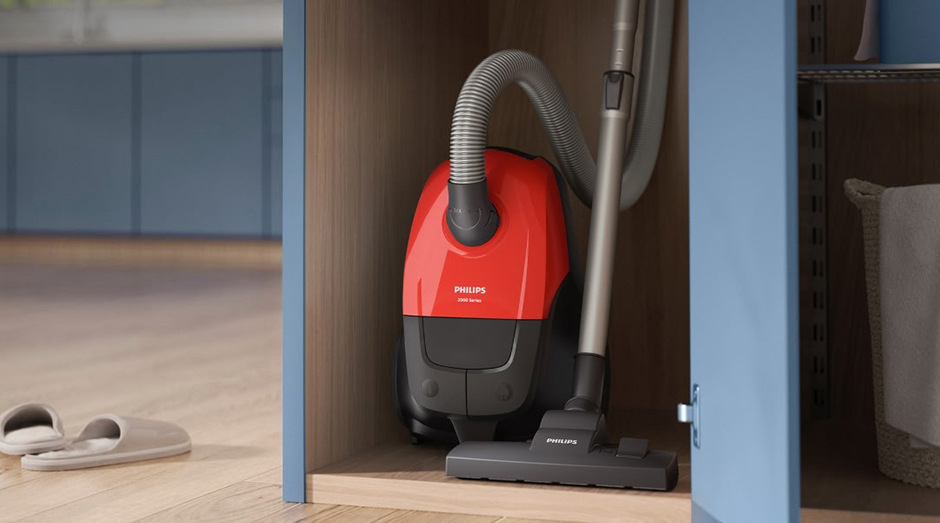 Kompaktný vreckový vysávač Philips XD1111/10 1000 Series uložený v skrini pre ľahké skladovanie.