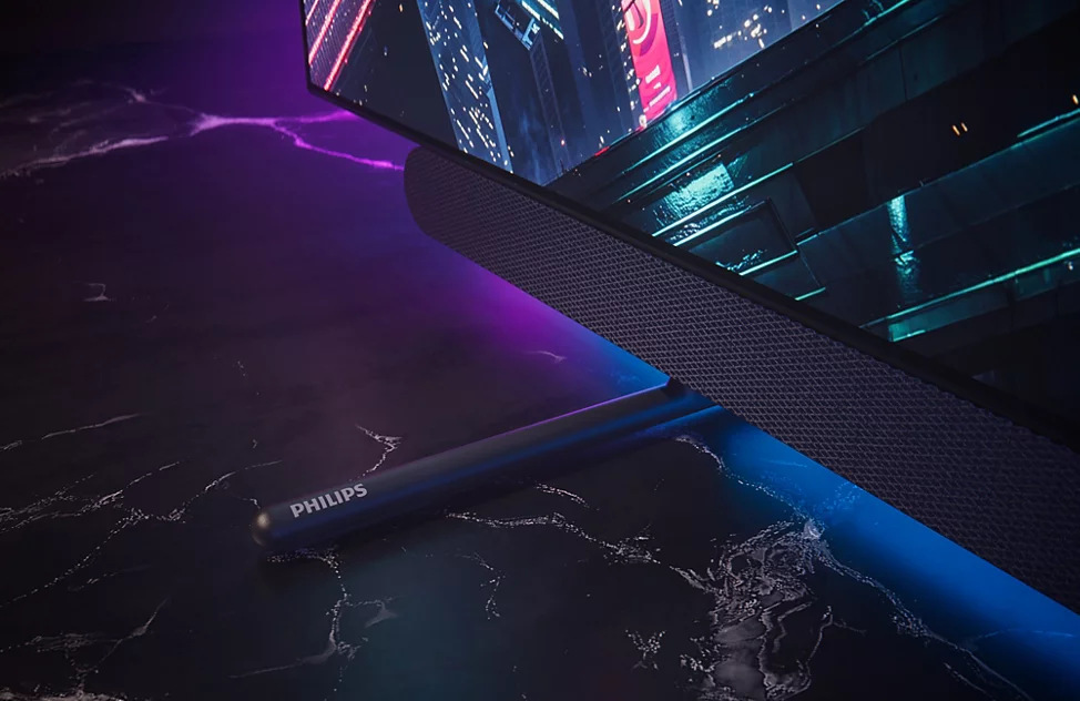 Detail rohu integrovaného soundbaru televízie Philips s vyrazeným logom značky.