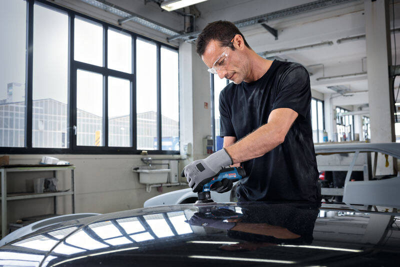 Excentrická brúska Bosch Professional GEX 12V-77 (bez baterie) Práca s akumulátorovou excentrickou brúskou Bosch na karosérii auta v autoservise s ochrannými okuliarmi