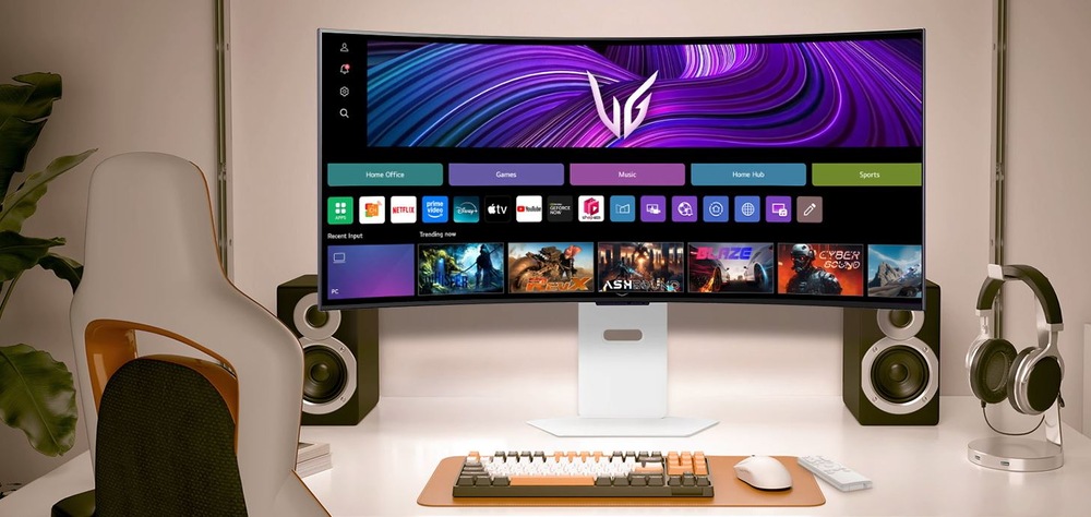 Moderná herná zostava sa vyznačuje veľkým zakriveným monitorom zobrazujúcim živé aplikácie a hry. Elegantná odkladacia plocha pre klávesnicu a myš je umiestnená na stole. Reproduktory a slúchadlá dotvárajú pohlcujúcu atmosféru.