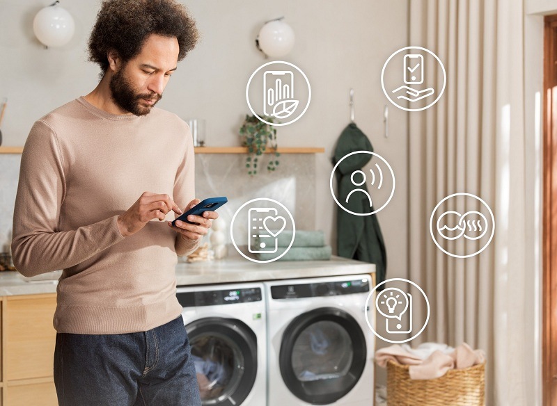 Práčka Electrolux UniversalDose UltraCare 800 EW8F3494SQC biela Muž ovláda práčku Electrolux pomocou mobilnej aplikácie.