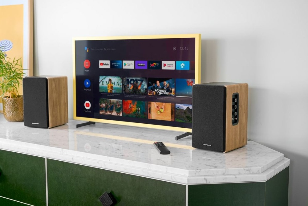 Reproduktory Thomson WS902DUO (2 ks) hnedé Reproduktory Thomson WS902DUO na stolíku okolo televízie