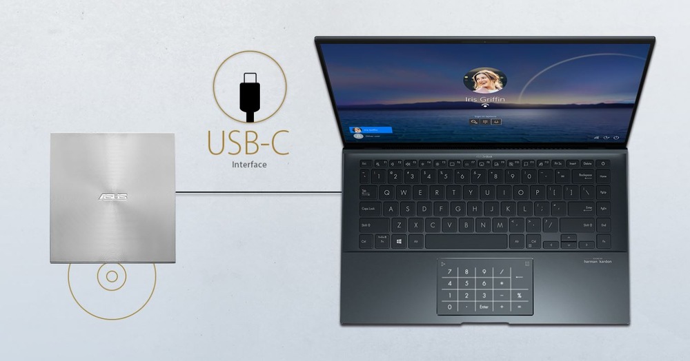 Notebook vpravo s prihlasovacou obrazovkou profilu, pripojený cez USB-C k externej DVD napaľovačke Asus po ľavej strane.