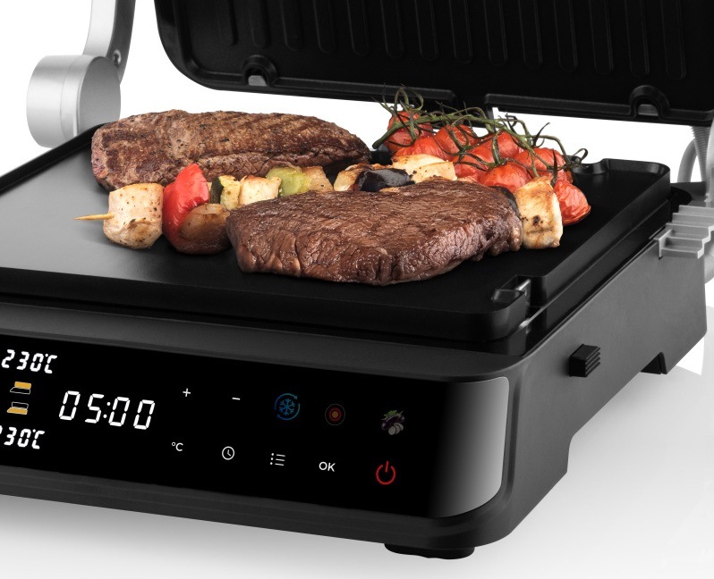 Detailný pohľad na otvorený kontaktný gril ETA DigiChef s grilovanými steakmi, špízmi a paradajkami a rozsvieteným digitálnym displejom