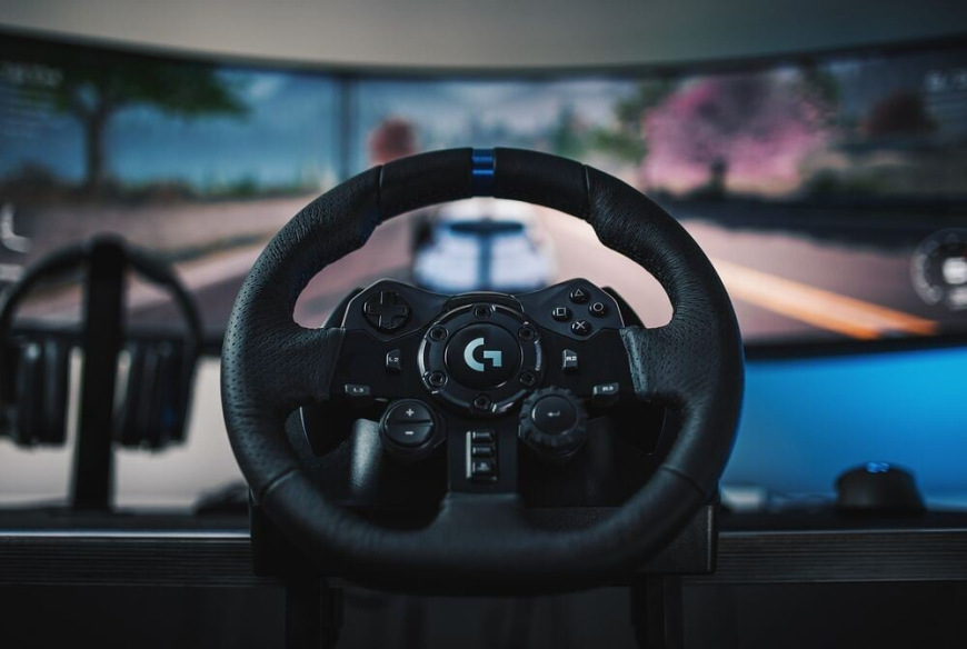 Volant Logitech G923 SE Racing Bundle wheel + pedals + shifter (PS/PC) čierny Volant Logitech G923 SE pri hraní závodnej hry – zaberá hlavnú pozíciu pred širokouhlým monitorom s rozostrenou závodnou scénou v pozadí