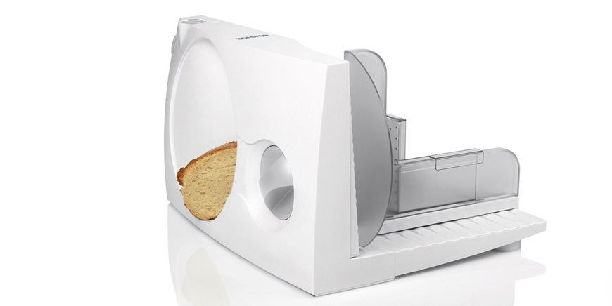 Zadný pohľad na biely krájač Gorenje R401W, kde sa práve krája pečivo.