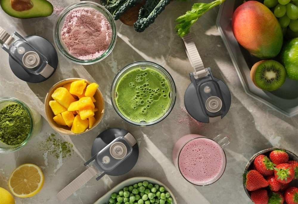 Na stole sú veká mixéra Electrolux, misky s ovocím a poháre s hotovým smoothiom.
