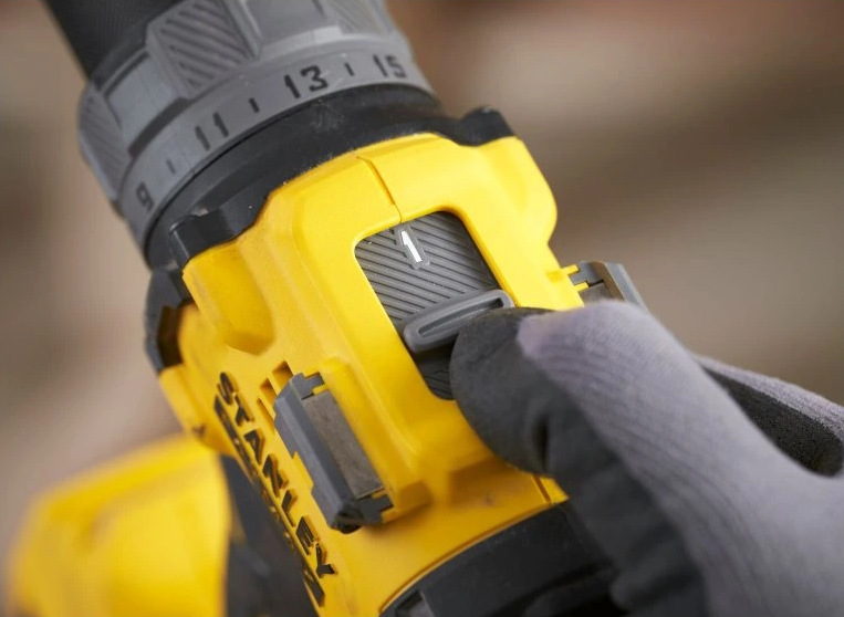 Aku vŕtačka Stanley FatMax SFMCD726D2T-QW (s baterií) Detail prepínača rýchlostí aku vŕtačky Stanley FatMax V20 v rukavici chránenej ruke.