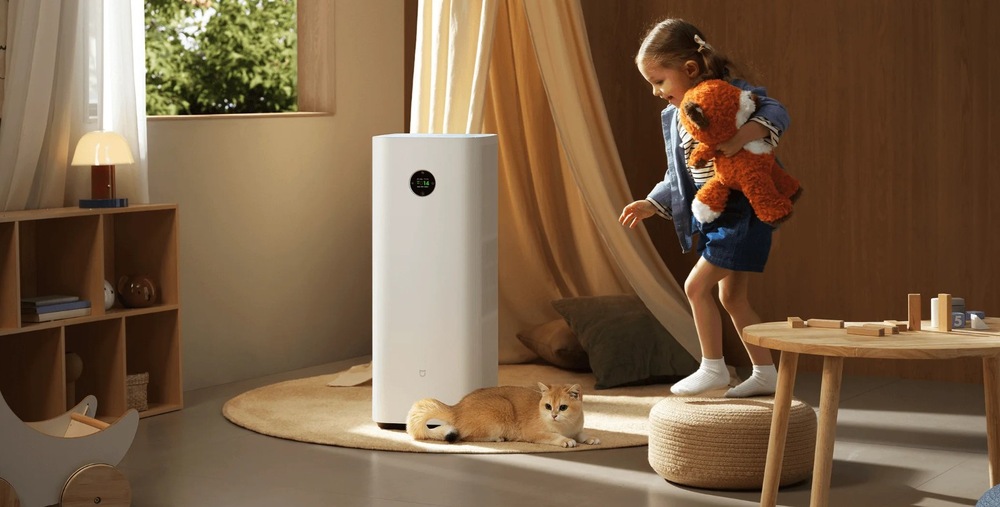 čistička vzduchu Xiaomi Miji Smart Air Purifier Max je postavená uprostred detskej izby, vedľa leží mačka a hrá sa tam dievčatko.