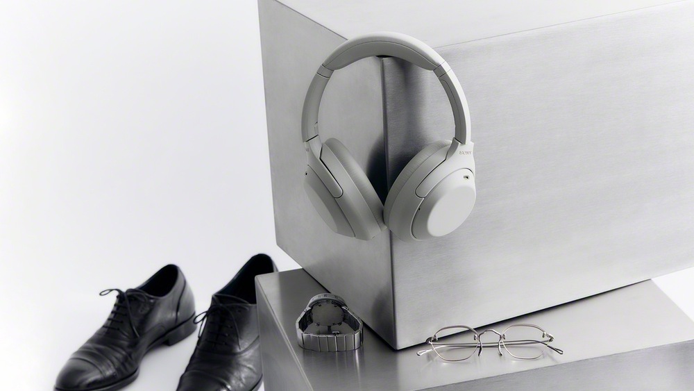Slúchadlá Sony WH-1000XM4C zavesené na nábytku vedľa obuvi