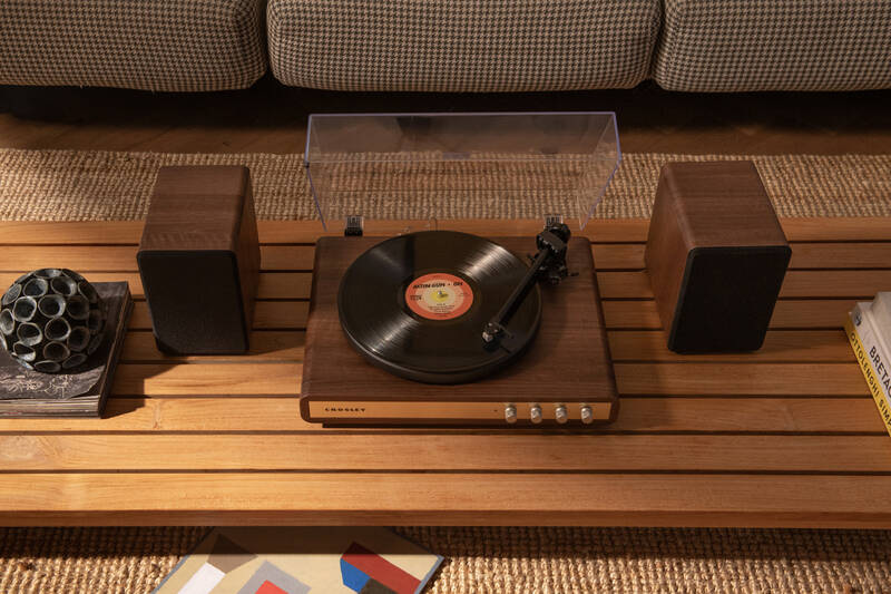 Gramofón Crosley C65 hnedý Gramofón Crosley C65 s externými reproduktormi umiestnený v interiéri, vinylová doska na tanieri