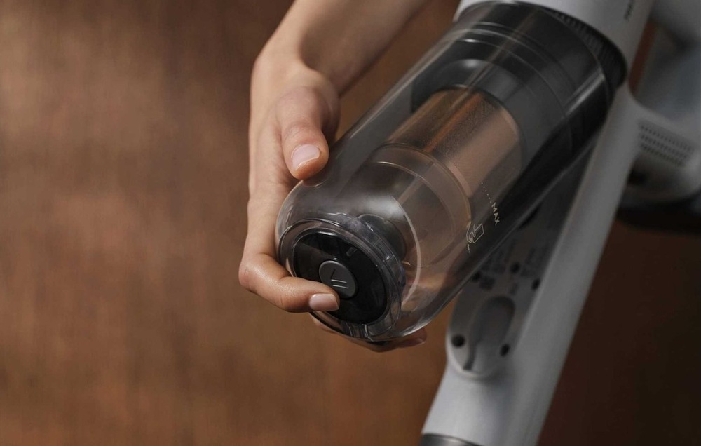 Tyčový vysávač Electrolux 700 Animal EP72AB21UG sivý Žena stlačením tlačidla oddeľuje prachovú nádobku od tela vysávača.