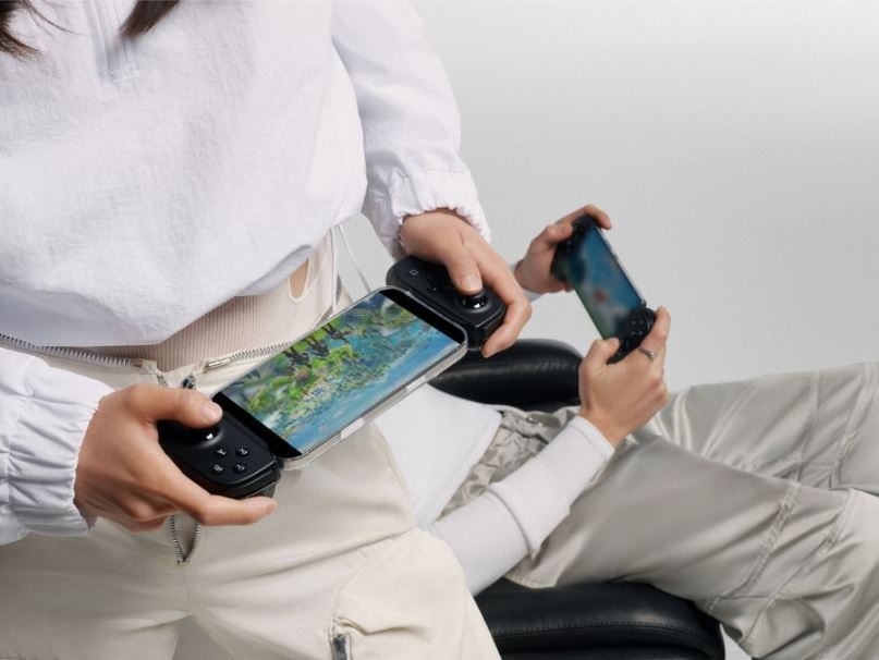 Gamepad Backbone Pro USB-C čierny Žena drží Gamepad Backbone Pre USB-C s mobilným telefónom v ruke, detail