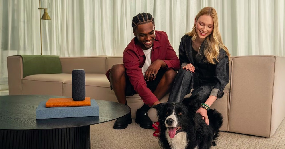 Prenosný reproduktor Motorola Moto Sound Flow béžový Muž so ženou sedí na pohovke, hladí psa a na stole majú reproduktor Motorola Moto Sound Flow