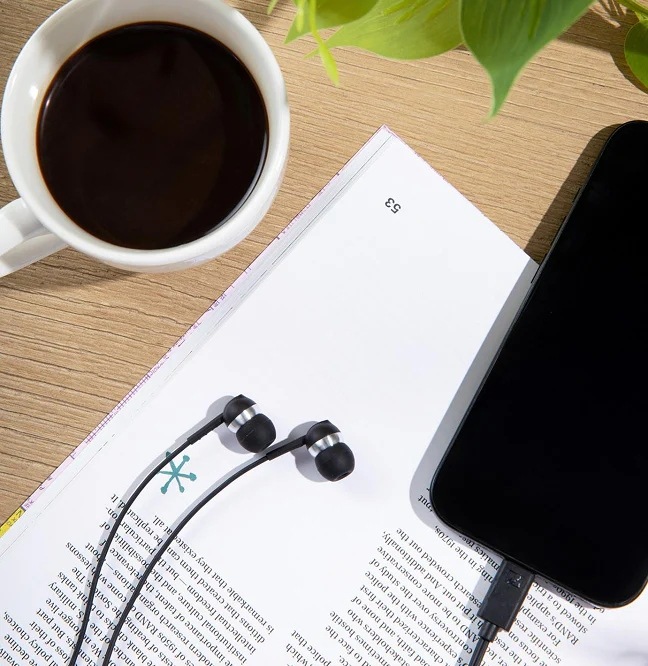 Slúchadlá Sennheiser CX80U čierna Na knihe položené slúchadlá Sennheiser CX80U a smartphone