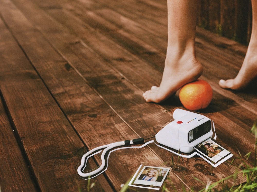 Instantný fotoaparát Polaroid Go Gen 3 biely Zátišie s fotoaparátom Go Gen 3 a vytlačenými portrétmi