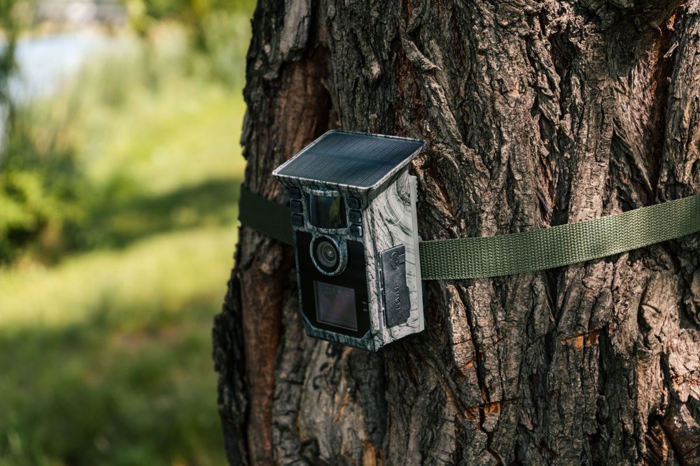 Fotopasca Technaxx TX-326 sivá Fotopasca so solárnym panelom na strome v lese.