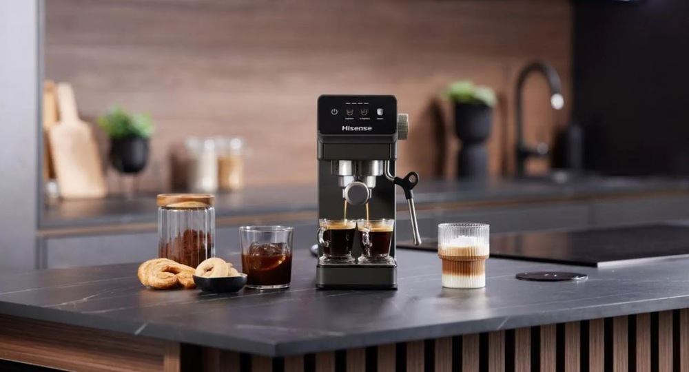 Espresso Hisense HESCM20LP antracitová farba pákový kávovar Hisense HESCM20LP na tmavo kuchynskej linke pripravuje dve espressá, vedľa stojí nachystane latte.