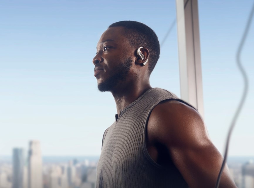 Slúchadlá Shokz OpenFit PRO, Bluetooth biela Posilňujúci muž má na ušiach slúchadlá OpenFit PRO