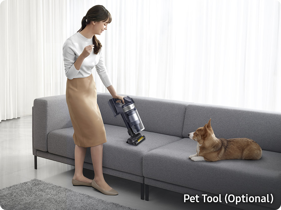 Žena vysáva pohovku tyčovým vysávačom Samsung Jet 75 VS20B75AER1/GEs nástavcom Pet Tool, na pohovke leží pes a pozoruje, v pravom dolnom rohu je nápis Pet Tool (Optional)