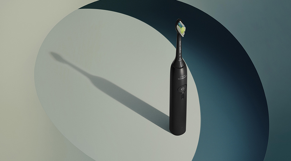 Zubná kefka Philips Sonicare 3100 HX4033/32 čierna Stojaca kefka Philips HX4033/32 Sonicare 3100 a za ňou tieň