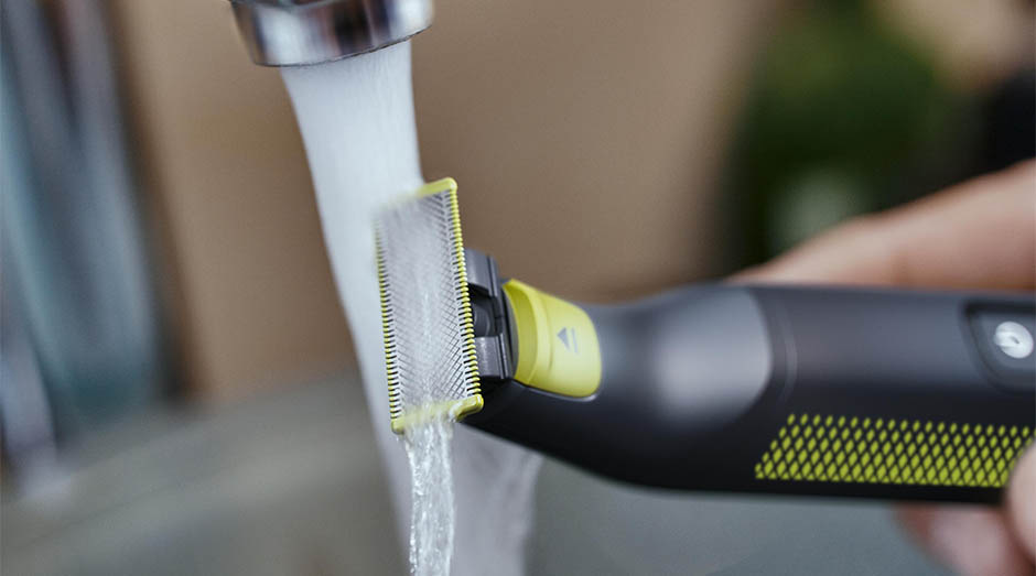 Zastrihávač fúzov Philips OneBlade Pro QP6506/15 čierny Muž umýva zastrihávač fúzov Philips QP6506/15 OneBlade Pro pod tečúcou vodou