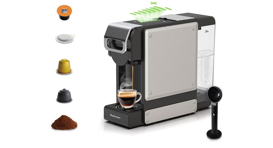 Kávovar Rohnson R-98054, je vidieť, na aké kapsule je vhodný a stupnica množstvo pripravenej kávy. Prístroj pripravuje espresso a vedľa je nachystaná lyžica/dávkovač na mletú kávu.