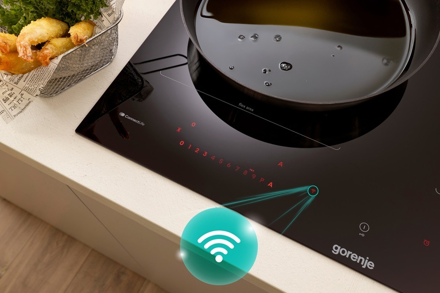 Detailný záber na ľavý roh indukčnej varnej dosky Gorenje GI6443BSCWF. Tá je vybavená vstavanou Wi-Fi pre jednoduché prepojenie varnej dosky s mobilnou aplikáciou ConnectLife.