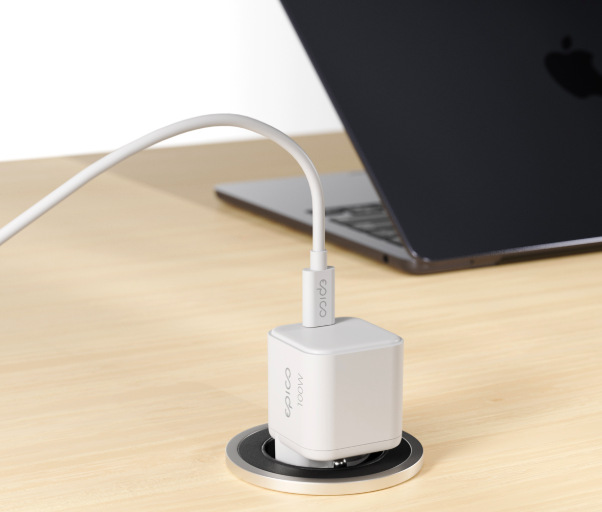 Nabíjačka do siete Epico UltraBoost Micro AVS GaN 100W biely Napájací adaptér Epico UltraBoost Micro AVS GaN 100W zapojený do zásuvky stola pri nabíjaní notebooku