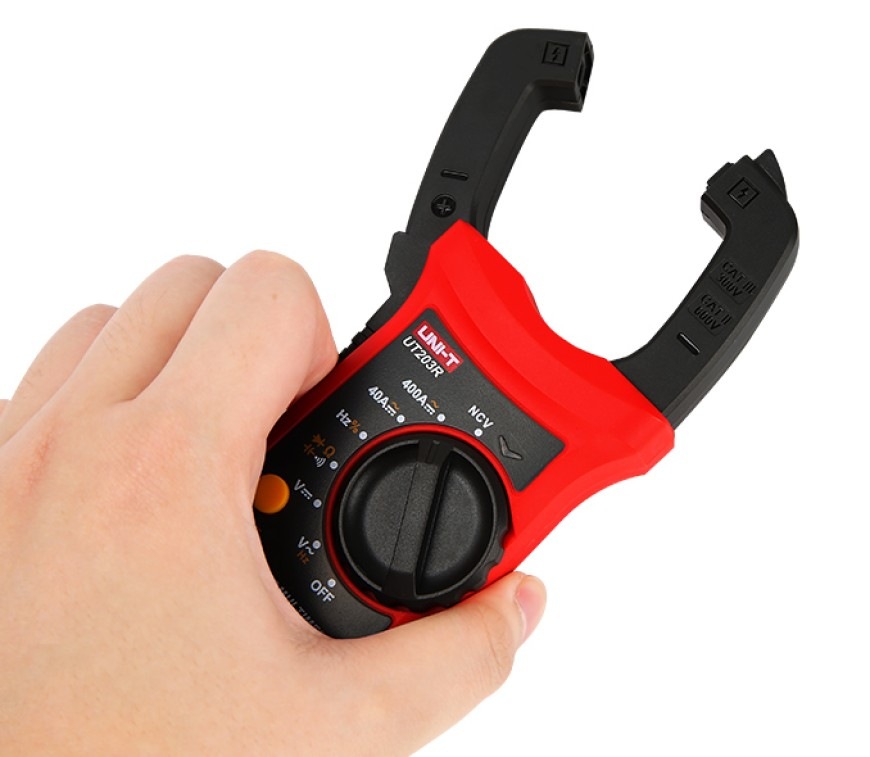 Ruka drží kliešťový multimeter UT203R