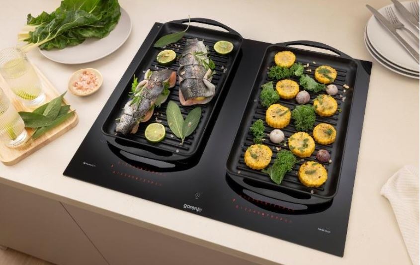 Indukčná varná doska Gorenje G600 GI6442MSCWF InfiniteMatt čierna Díky propojení varnych zon do jedne velke se na desce vari ve velkach nadobách. Na jedne strane je ryba a na druhe brambory.