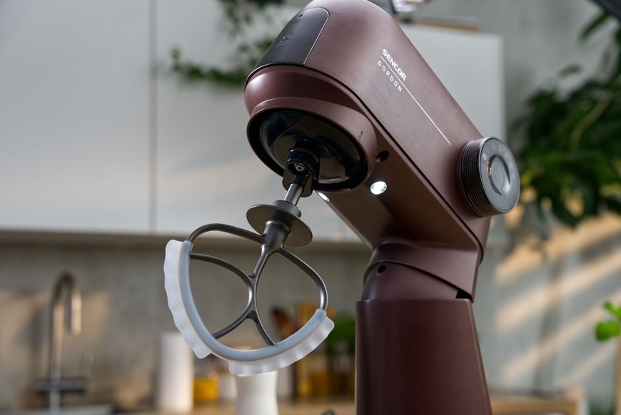 Detailný záber na celokovový kuchynský robot značky Sencor vo fialovom prevedení. V spodnej časti má zariadenie LED osvetlenie pre lepší prehľad pri príprave.