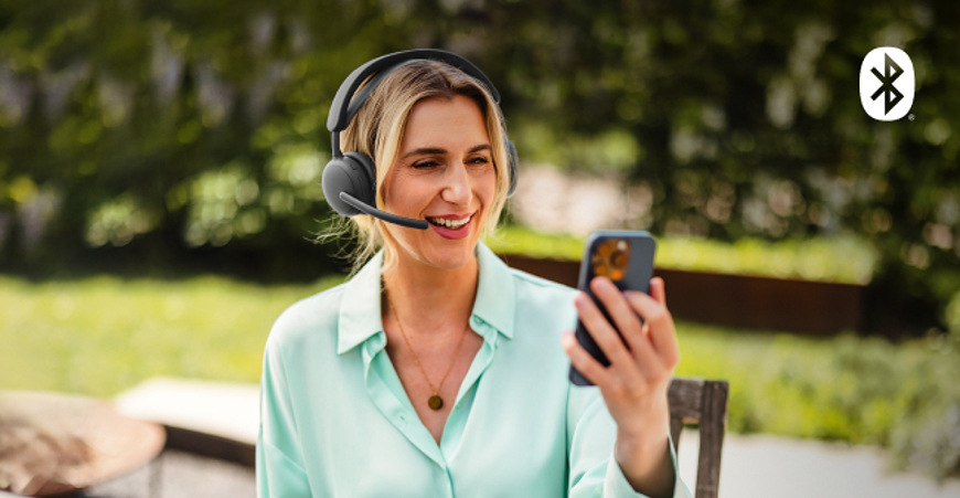 Headset Logitech Zone Wireless 2 ES sivý Žena volajúca cez telefón s headsetom Logitech Zone Wireless 2 ES vonku na záhrade