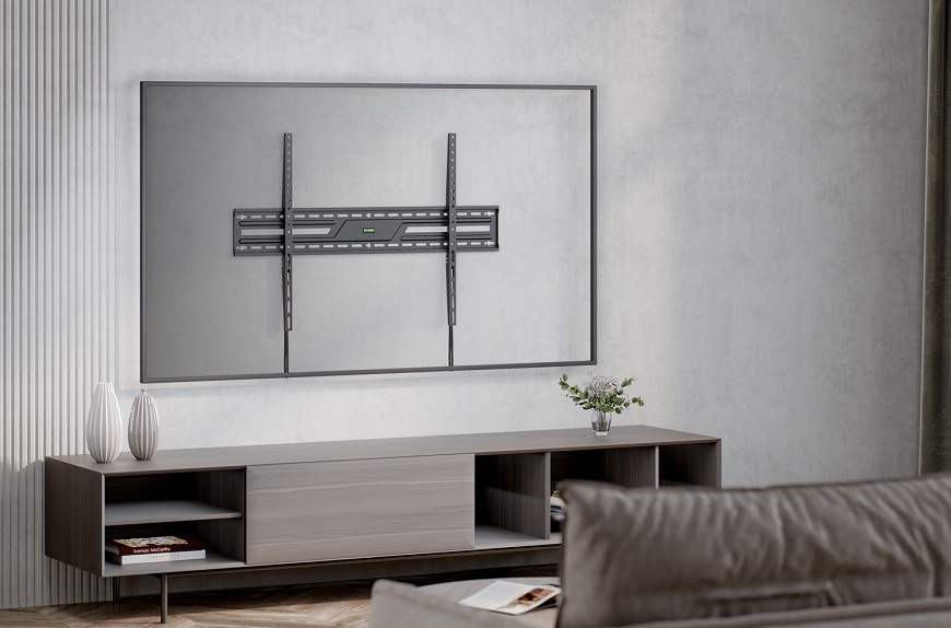 Držiak na TV GoGEN fixní XXL čierny Fixný držiak na TV GoGEN namontovaný na šedej stene nad televíznou skrinkou