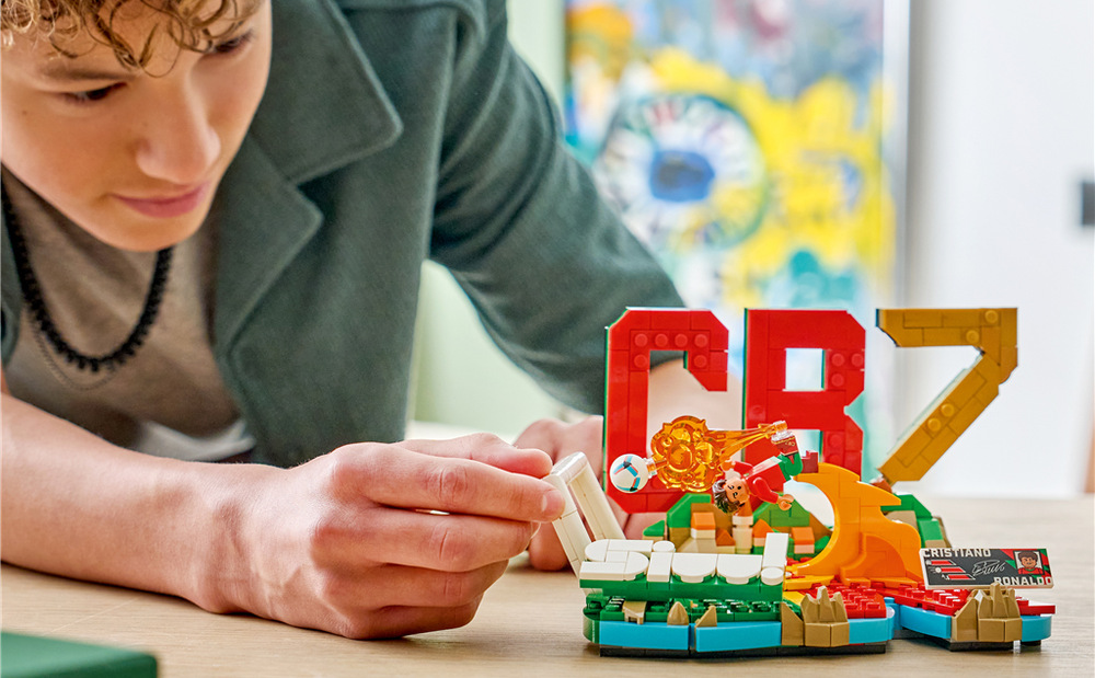 Stavebnica LEGO® Editions 43012 Cristiano Ronaldo – Hvězdné momenty fotbalu Podstavec zdobia iniciály, portugalské farby, označenie CR7 a plaketa s podpisom a štatistikami hráča