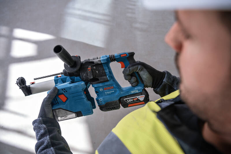 Muž drží v rukách vŕtacie kladivo Bosch Professional GBH 18V-22.
