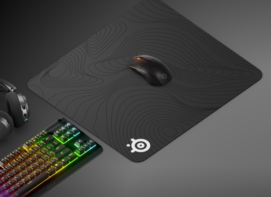 Podložka pod myš SteelSeries QcK Large, Topographic čierna Myš na podložke QcK Large Topographic vedľa headsetu a klávesnice s RGB podsvietením