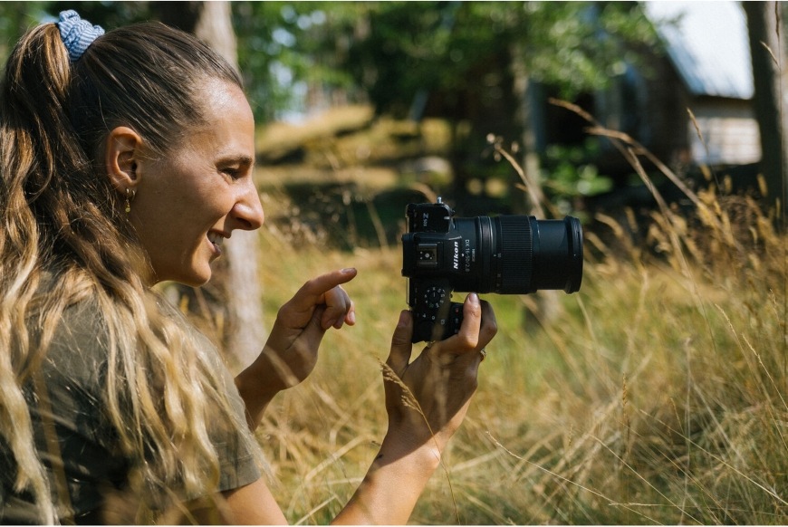 Objektív Nikon Z DX 16-50 mm f/2.8 VR čierny Žena fotografujúca s objektívom NIKKOR Z DX chváliacim sa vysokou svetelnosťou