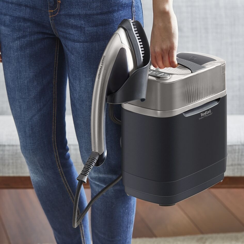 Muž prenáša naparovač Tefal QT2028F0 Ixeo Power
