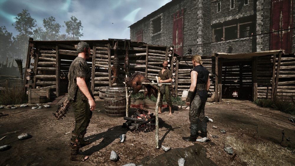Záber z hry Gothic Remake. Tri postavy stoja okolo ohňa v rustikálnom drevenom tábore. Jeden z nich si na ohni opeká mäso.