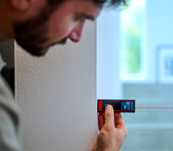 Laserový diaľkomer Einhell Classic TC-LD 40 R Meranie vzdialenosti laserovým diaľkomerom Einhell Classic TC-LD 40 R priloženým k stene v interiéri